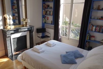 Full-length double windows flood the bedroom with light